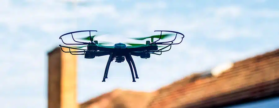 Drone quad copter flying over the roofs. Drone photography and videography. Toy drone. Copy space