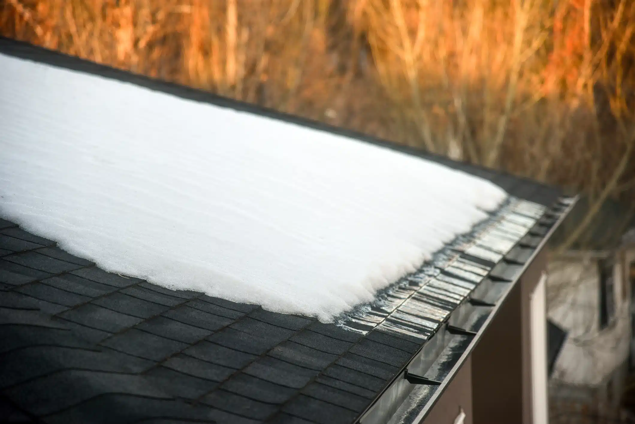 Snow melting on shingled roof with eavestrough